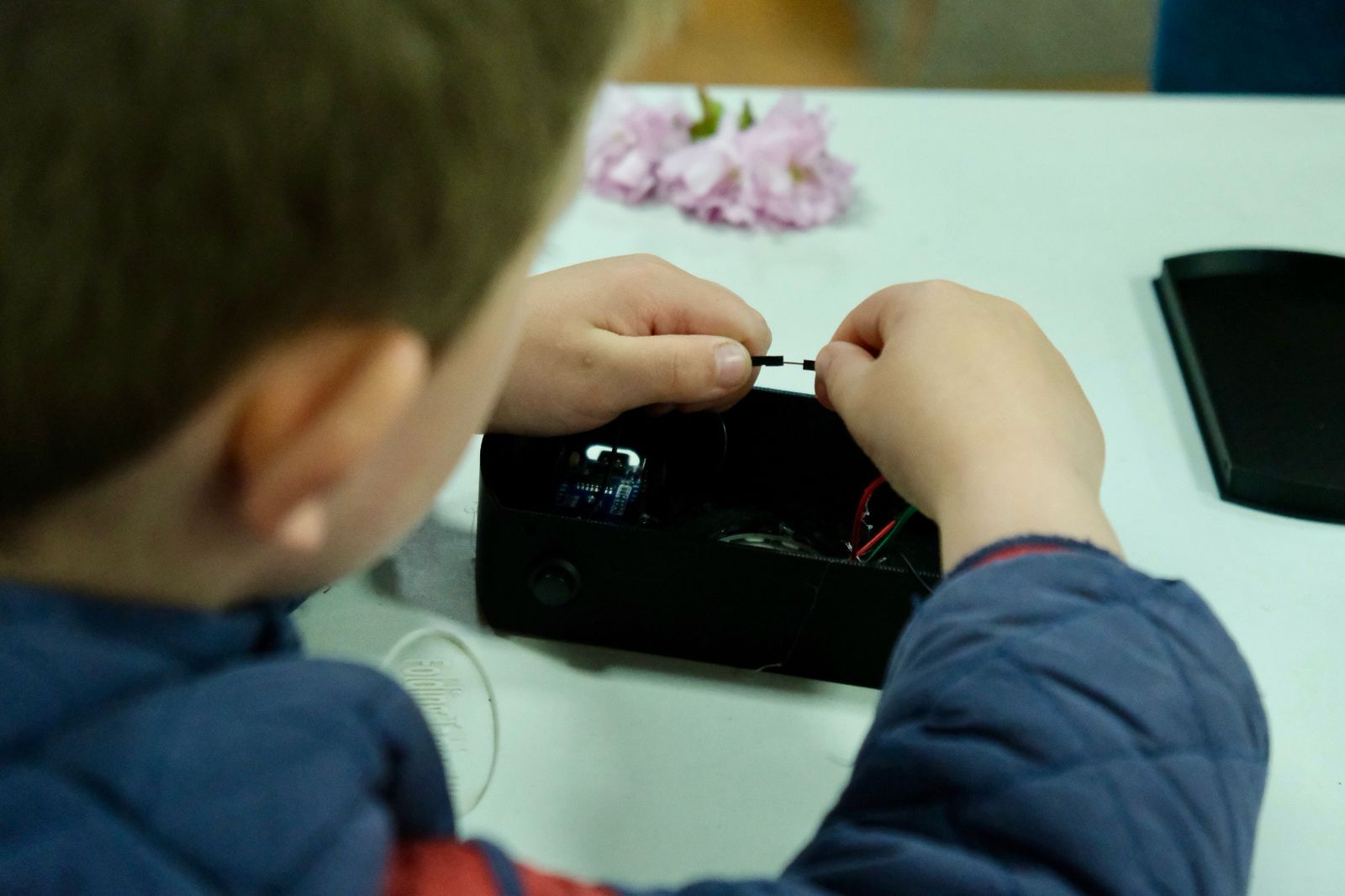 Child making a connection on an electronics project