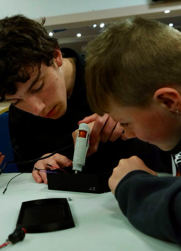 Teenager helping younger child with Easter Glow project